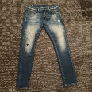 Blå jeans från dondup - Snygga blå jeans från Travis i slim fit med slitna detaljer och en klassisk femficksdesign. Perfekta för en avslappnad stil med en modern touch. De har en dragkedja och knapp framtill.