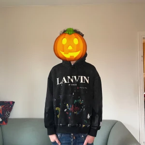 Lanvin x galerie dept  - Säljer en svart hoodie från Lanvin x gelerie dept med tryck på framsidan och text på baksidan. Hoodien har en avslappnad passform och långa ärmar. Perfekt för en skön och bekväm stil.