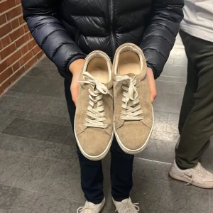 Beige sneakers från Vagabond - Säljer ett par snygga beige sneakers från Vagabond. Skorna har en stilren design med snörning och är tillverkade i mocka. Perfekta för en avslappnad stil. Org pris 1400
