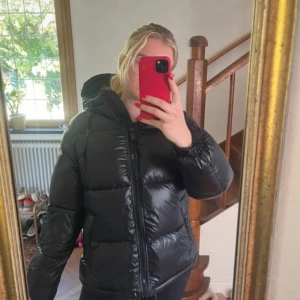 Svart, glansig pufferjacka från h&m - Säljer min superfina svarta, glansiga pufferjacka från h&m. Jackan är i bra skick men saknar snörerna.