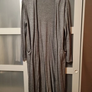 Kofta - Lång fin stickad kofta med fickor. Sparsamt använd.