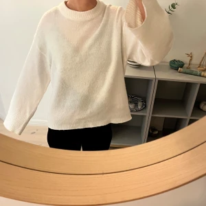 Vit stickad tröja från H&M - Mysig vit stickad tröja från H&M med rund hals och långa ärmar. Perfekt för kyliga dagar och enkel att matcha med olika outfits. Tröjan är lite nopprig!