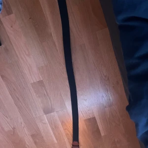 Blåt flätat bälte med bruna detaljer - Snyggt blåt flätat bälte  med bruna detaljer, perfekt för att komplettera din outfit. Bältet har en stilren design och passar till många olika stilar.