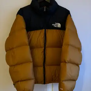 En mycket fin jacka från TNF i storlek L. Använd en vinter och är i gott skick. Färgen är Timber Tan (orange) och är gjord av 100% dun! Nypris runt 3000kr. Tveka inte på att höra av dig vid minsta lilla fundering!