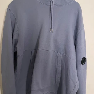 C.P Company Hoodie - Ljusblå C.P Company Hoodie utan goggles. Bra skick, sitter normal i storleken och har inga fläckar eller hål. Skriv för fler bilder eller frågor. 