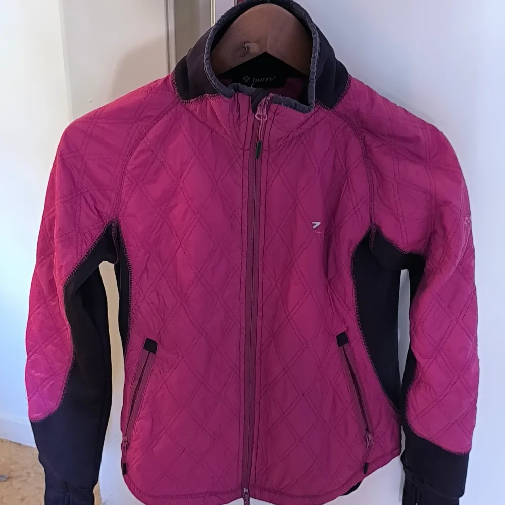 Säljer en snygg rosa quiltad jacka från Horze Den har lila detaljer på sidorna och ärmarna, Jackan är gjord av 100% polyester med inslag av elastan för extra stretch. Perfekt för höst och vår. Använd men inga skador eller slitsge.strl 36. Jackor.