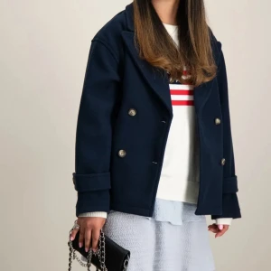 Mörkblå skepparkavaj - Säljer en  mörkblå kappa med dubbelknäppning. Köpt på kids Brand Store. Perfekt för höst och vår. Storlek 158/164 som motsvarar XS/S. Jackan har långa ärmar och är i bra skick. 