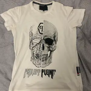 Helt skitzad vit t-shirt från Philipp Plein. T-shirten har en normal/slim passform. Perfekt för en avslappnad stil med en edgy twist. Detaljer finns både i nacken och på sidan.