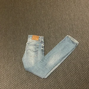 Blå slim fit jeans från Jack & Jones - Snygga ljusblå slim fit jeans från Jack & Jones, modell Glenn. De har en klassisk femficksdesign och en bekväm passform. Perfekta för en stilren look. Skriv vid funderingar!