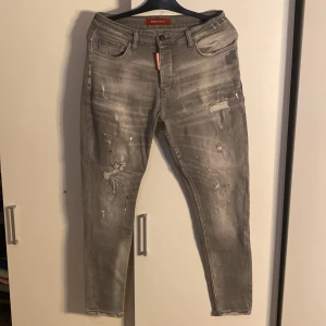 Grå jeans från Dsquared2 - Snygga grå jeans från Dsquared2 med en cool, sliten look. De har en klassisk femficksdesign och en knappgylf. Perfekta för en avslappnad stil med en touch av edge.