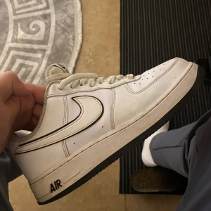 Nike Air Force 1  - Säljer ett par klassiska vita Nike Air Force 1 sneakers. Skorna har en stilren design med svart sula och den ikoniska Nike-loggan på sidan. Perfekta för en casual look. Har använts 5-10 gånger 