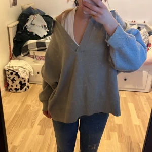 Grön/grå tröja från H&M - Säljer en stilren grå tröja från H&M med v-ringning och ribbade kanter. Inga defekter och säljs för att den inte används💗