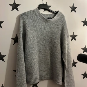 Grå stickad tröja från Shein - Mysig grå stickad tröja från Shein i storlek XS. Perfekt för kyliga dagar med sin mjuka och bekväma passform. Tröjan har långa ärmar och en rund halsringning.