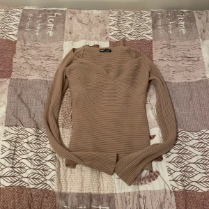 Beige ribbad topp från Zara - Snygg beige ribbad topp från Zara med långärmad design och en v-ringad hals. Perfekt för en stilren look. Passar bra till både jeans och kjol.