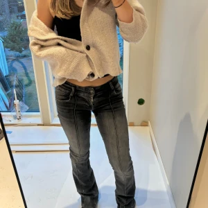 Svarta jeans med bootcut - Snygga svarta jeans, bootcut och låg midja. De har en dragkedja och knappar framtill. Äskar dessa men kommer inte till så mycket användning längre, dma för fler frågor!❤️ De två första bilderna är olika ljus🥰De är ca 34 i midjan innerben 79/80