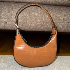 Brun mini axelväska med krokodilmönster - Söt mini  axelväska i syntet med krokodilmönster.