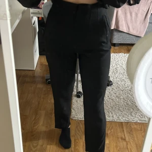 Svarta kostymbyxor från Zara - Snygga svarta kostymbyxor från Zara med hög midja och snygg passform. Knappt använda och passar till mycket.