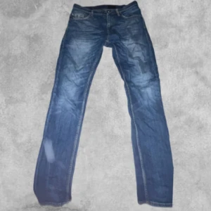 Blå jeans från Tiger of Sweden - Snygga blå jeans från Tiger of Sweden med klassisk femficksdesign. De har en normal passform och är tillverkade i slitstarkt denim. Perfekta för en avslappnad stil.