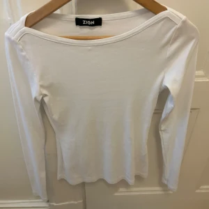 Vit långärmad topp från Zign - Säljer en stilren vit långärmad topp från Zign. Perfekt för en minimalistisk look. Toppen har en enkel design med rund hals och är tillverkad i ett mjukt material.