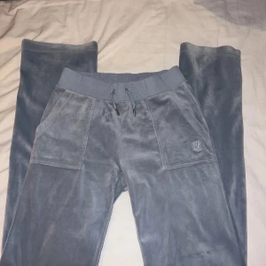 Ljusblå mjukisbyxor från Juicy Couture XS - Snygga och bekväma grå mjukisbyxor från Juicy Couture. Byxorna har en loose passform med snörning i midjan och praktiska fickor både fram och bak. STORLEK XS!! Det är en pytte liten fläck på framsidan ben. Tvättar innan den postas!