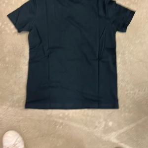 Svart t-shirt - En stilren svart t-shirt med korta ärmar. Perfekt för en enkel och avslappnad look. Passar bra till jeans eller shorts.