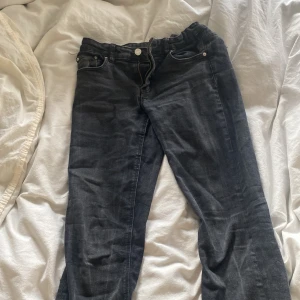Svarta jeans från Gina Tricot - Snygga svarta jeans från Gina Tricot. Jeansen har snygga svaga vita linjer på sig! Lågmidjade bootcut svarta jeans, skulle säga att byxorna passar 152/158!!!