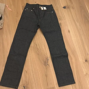 Selvege denim A.P.C. - Snygga selvege jeans från A.P.C. i modellen 'Jean Standard'. De har en klassisk femficksdesign med knappgylf och är tillverkade i högkvalitativt denim. Perfekta för en stilren look. Nypris ca. 2000