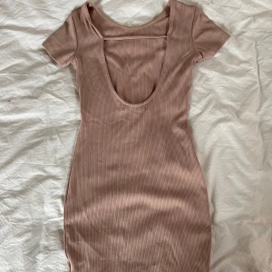 Ribbad rosa klänning - Beige/rosa kort klänning med öppen rygg, från Bikbok i storlek XS. Använd fåtal gånger💛