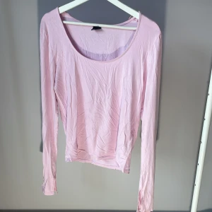 Rosa långärmad topp från Gina Tricot - Säljer en söt rosa långärmad topp från Gina Tricot. Perfekt för en avslappnad stil med sin mjuka och bekväma passform. Toppen har en rund halsringning och är tillverkad i ett lätt material.