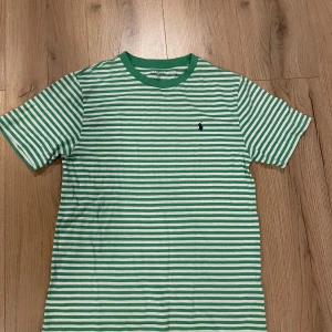 Polo Ralph Lauren t-shirt Randig - Snygg grön- och vitrandig t-shirt från Polo Ralph Lauren. Den har korta ärmar och en klassisk passform.