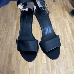 Svarta sandaler med kilklack - Snygga svarta sandaler med kilklack och justerbart spänne runt ankeln. 