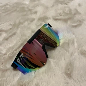 Sportiga solglasögon med regnbågsspegelglas - Snygga och sportiga solglasögon från PIT Viper med regnbågsspegelglas och svart båge. Perfekta för utomhusaktiviteter med en modern och iögonfallande design.