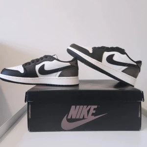 Air Jordan 1 Mochas  - Snygga Jordan 1 i klassisk mochas färgkombination. Skorna har en stilren design med snörning och den ikoniska Air Jordan-loggan på hälen. Skona har samma färgkombination som de kända travis scott. Perfekta för dig som vill ha en tidlös sneakerstil.