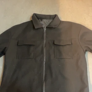 Svart fleecejacka med dragkedja - Säljer en svart fleecejacka med dragkedja och två bröstfickor. Perfekt för en stil ren outfit  och enkel att matcha med andra plagg. Större i storlek!! Precis från Paket