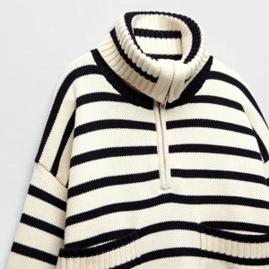 Randig stickad tröja från Zara - Säljer en snygg randig tröja från Zara i svart och vitt. Tröjan har en hög krage att antingen vika eller ha som polo. Tröjan har en  dragkedja och långa ärmar med två fickor på framsidan. Perfekt för en stilren look.