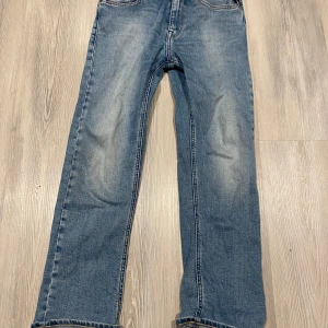 Blå jeans från Replay - Snygga blå jeans från Replay med klassisk femficksdesign och knappgylf. De har en straight passform och är perfekta för en avslappnad stil. Detaljer som broderade bakfickor ger en extra touch.