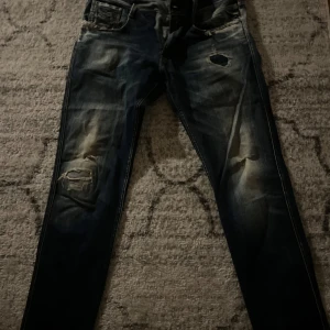 Replay jeans storlek 34  - Säljer ett par mörkblå jeans med coola slitningar på knäna. De har en klassisk femficksdesign och en snygg tvättad look. Perfekta för en avslappnad stil. Skriv för mer info 