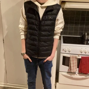 Svart dunväst från Gant - Säljer en riktigt snygg dunväst perfekt för våren eller kanske under en jacka. Nypris 1600. Mycket bra skick!