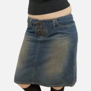 Jeanskjol med snörning - Så snygg jeanskjol från 90/00-talet köpt i vintage butik i USA. Den är helt oanvänd av mig och är i bra skick. Står ingen storlek men skulle säga att den passar s/m då den är lite stretchiga och har snörning. Hör av dig om du har några frågor :)