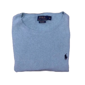 Ljusblå tröja från Ralph Lauren - Snygg ljusblå tröja från Ralph Lauren med rund hals och det klassiska logotypbroderiet på bröstet. Perfekt för en stilren look.