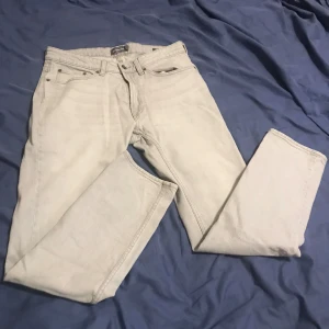 Ljusa jeans från Dressmann - Säljer ett par ljusa jeans från Dressmann i regular fit. Perfekta för en avslappnad stil med klassisk design. Passar bra till både vardag och mer uppklädda tillfällen.