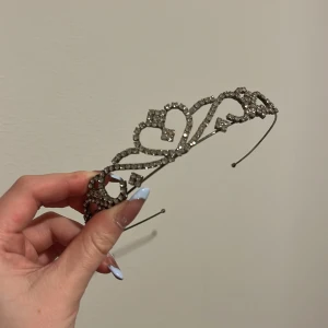Glittrigt diadem med hjärtmönster - Snyggt diadem med glittriga detaljer och ett elegant hjärtmönster. Perfekt för att ge en extra touch till din look. Passar bra till festliga tillfällen.
