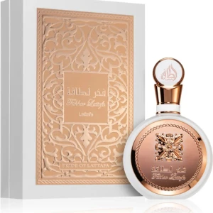 Lattafa Fakhar Rose edp 100ml - Elegant parfymflaska från Lattafa med en rund form och detaljer i guld och vitt. Förpackningen har ett intrikat mönster och text i guld. Perfekt för den som söker en lyxig doftupplevelse.