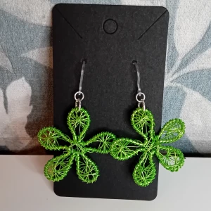 Gröna blommiga örhängen - Egentillverkade gröna örhängen formade som blommor. Öronkroken är gjord i plast och längden på örhängena är ca 4 cm långa.