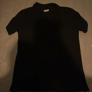 Svart t-shirt - En enkel och stilren svart t-shirt med korta ärmar. Perfekt för en minimalistisk look. Skön att ha till sommaren som kommer o se fräsch ut.