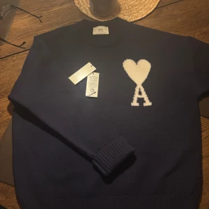 Mörkblå tröja från Ami - Helt ny mörkblå tröja från Ami Paris. Köpt i sommar och aldrig använd , kvitto finns ej då den är köpt från deras hemsida och sen sommaren har jag ej sparat emailet med kvittot, därmed priset 1900kr och inte nära ny pris 4300kr. Äkta ami Paris tröja , utifrån taggarna och kvaliteten på bilderna, särskilt loggan, kan man se autenticitet. Sök gärna upp hur man kollar autenticitet annars. Skriv gärna om ni har frågor.