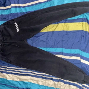 Svarta mjukisbyxor från Hoodrich - Säljer ett par svarta mjukisbyxor från Hoodrich i storlek XS. Byxorna har en bekväm passform med snörning i midjan och ribbade muddar vid bensluten. Perfekta för en avslappnad stil. 