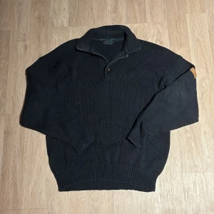 Mörk blå  stickad tröja med krage - Säljer en mörkblå stickad tröja med krage och dragkedja. Perfekt för kyliga dagar med sin mysiga och varma känsla. Tröjan har långa ärmar och ribbade muddar vid ärmslut och nederkant. Passar både till vardags och lite finare tillfällen.