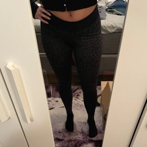 Svarta leopardmönstrade träningsbyxor - Säljer ett par snygga svarta träningsbyxor med leopardmönster. Materialet är mjukt och stretchigt, vilket gör dem superbekväma att ha på sig. Köparen står för frakten💞