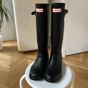 Svarta stövlar från Hunter - Säljer ett par klassiska svarta Hunter-stövlar i storlek 37. De är i mycket bra skick och perfekta nu! De är använda en gång, bara lite dammiga på bilden :) 